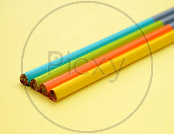 bunch of the colorful wooden pencils isolated on yellow background.