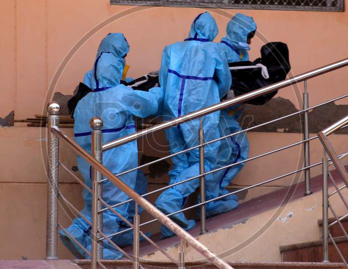 Health workers wearing hazmat suits carry the dead body of a person who died due to Covid-19 infection at a crematorium amid the ongoing lockdown in Ajmer Rajasthan on July 02, 2020.