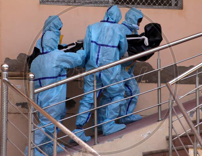 Health workers wearing hazmat suits carry the dead body of a person who died due to the coronavirus infection at a crematorium in Rajasthan on July 02, 2020.