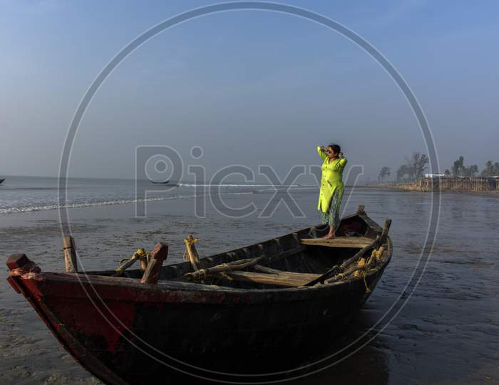 An Woman Standing On A Boat On A Sea Beach