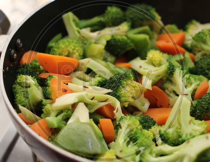 Half cooked vegetables on black fry pan