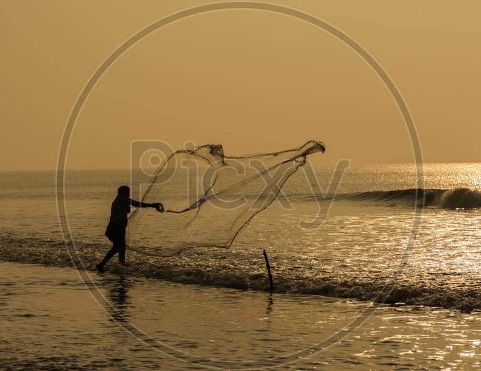 A Fisher Man Throwing His Fishing Net
