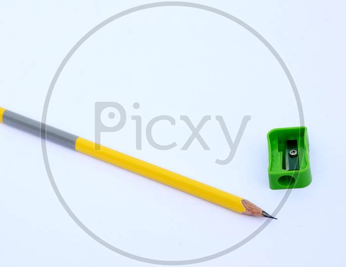 the yellow wooden pencil with green sharpner isolated on white background.