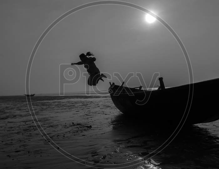 An Woman Jumping From A Boat On A Sea Beach