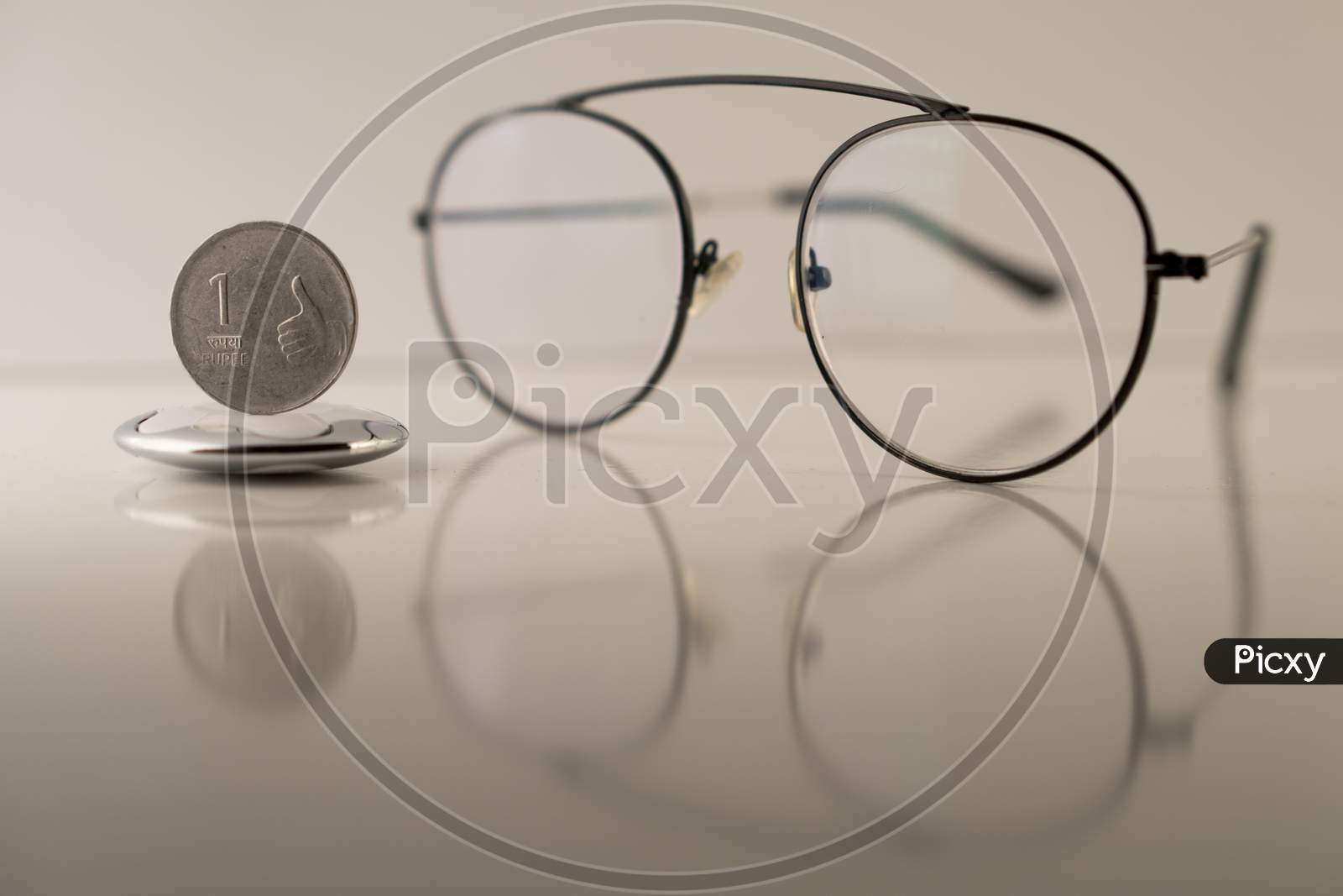 Indian rupee with spectacle against a white background . the image portrays the concept of value of Indian currency through the glasses of economist