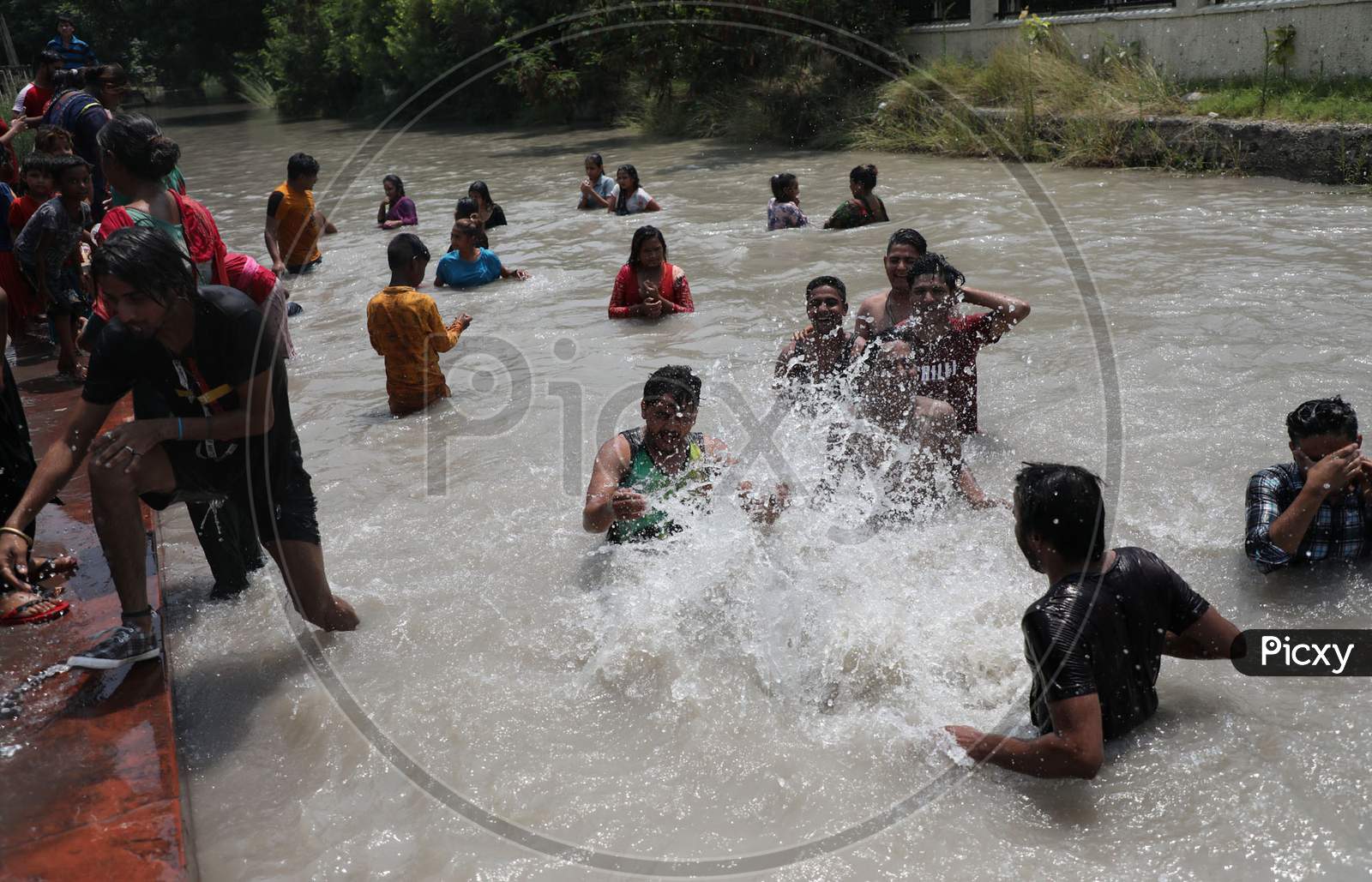 People enjoying themselves in Ranbir Canal as summer temperatures soar in Jammu on July 2, 2020.