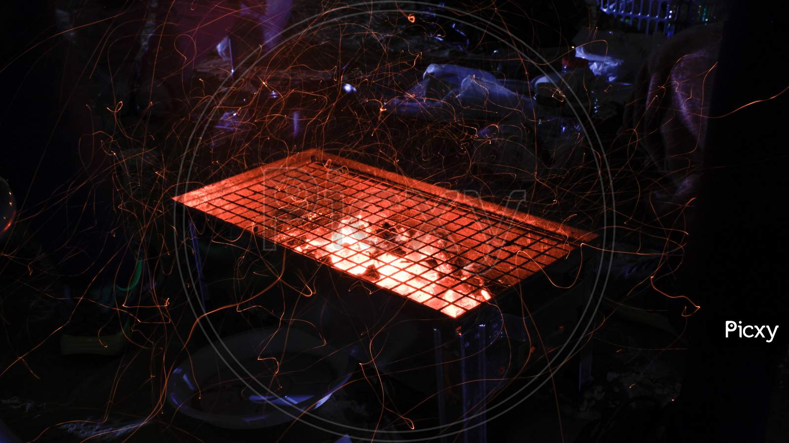 Hot Flaming Coal Burning In A Grill At A Barbeque Making Sparks, Long Exposure Light Trails Photo