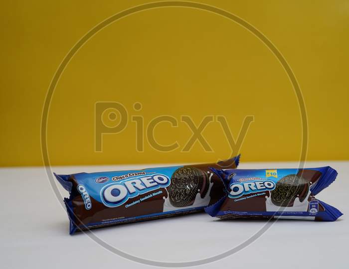 New Delhi, Delhi/ India- July 2 2020: Two Packets Of Oreo Biscuits Kept On A White Paper With Yellow Background.