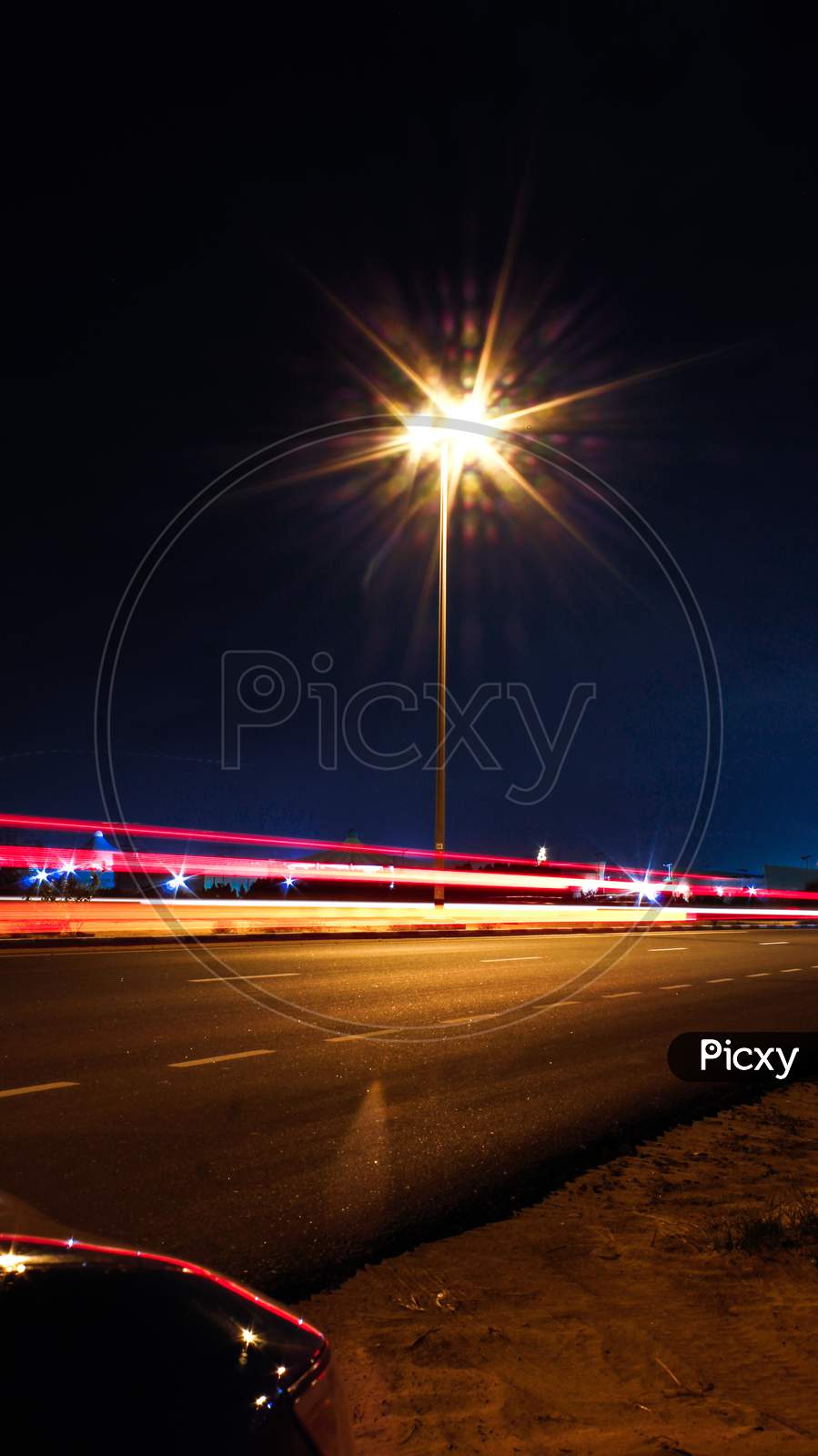 Long Exposure Of A Vehicle By The Road Side With Light Glare In The Night
