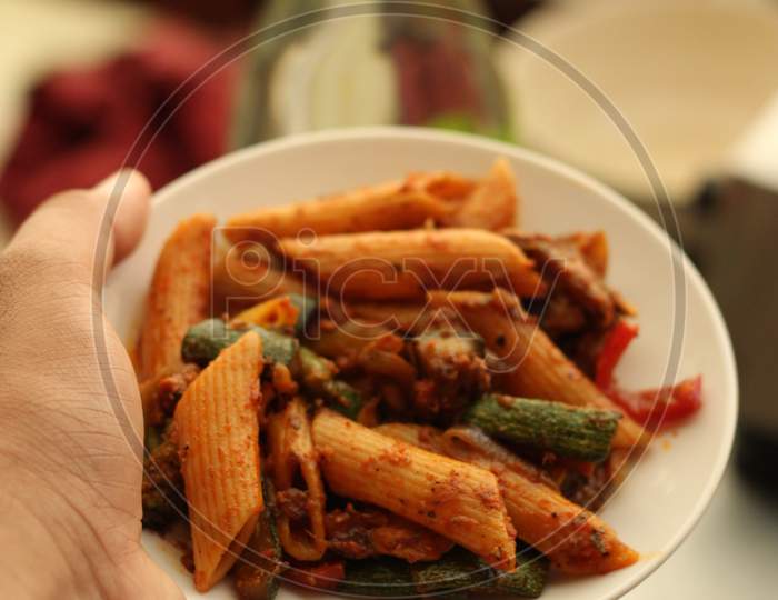 Spicy pasta on small white plate