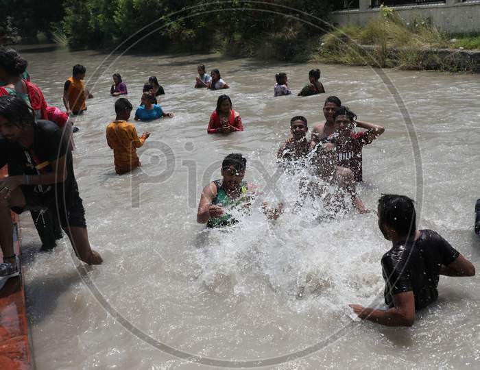 People enjoying themselves in Ranbir Canal as summer temperatures soar in Jammu on July 2, 2020.