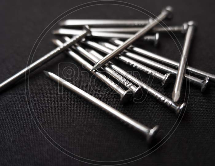 Closeup Shot Of Some Steel Nails On A Black Surface