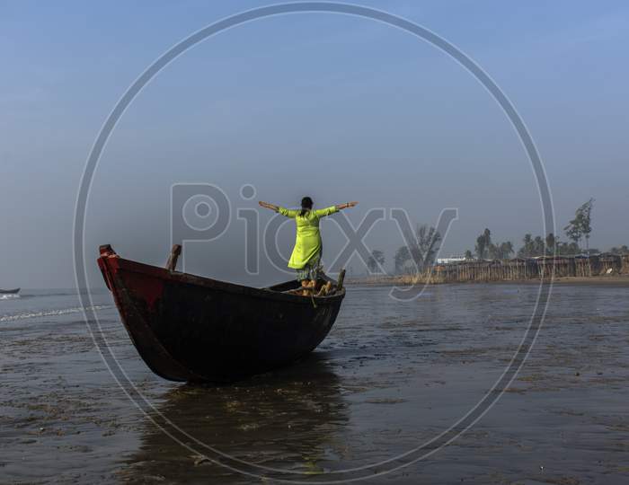 An Woman Standing On A Boat On A Sea Beach