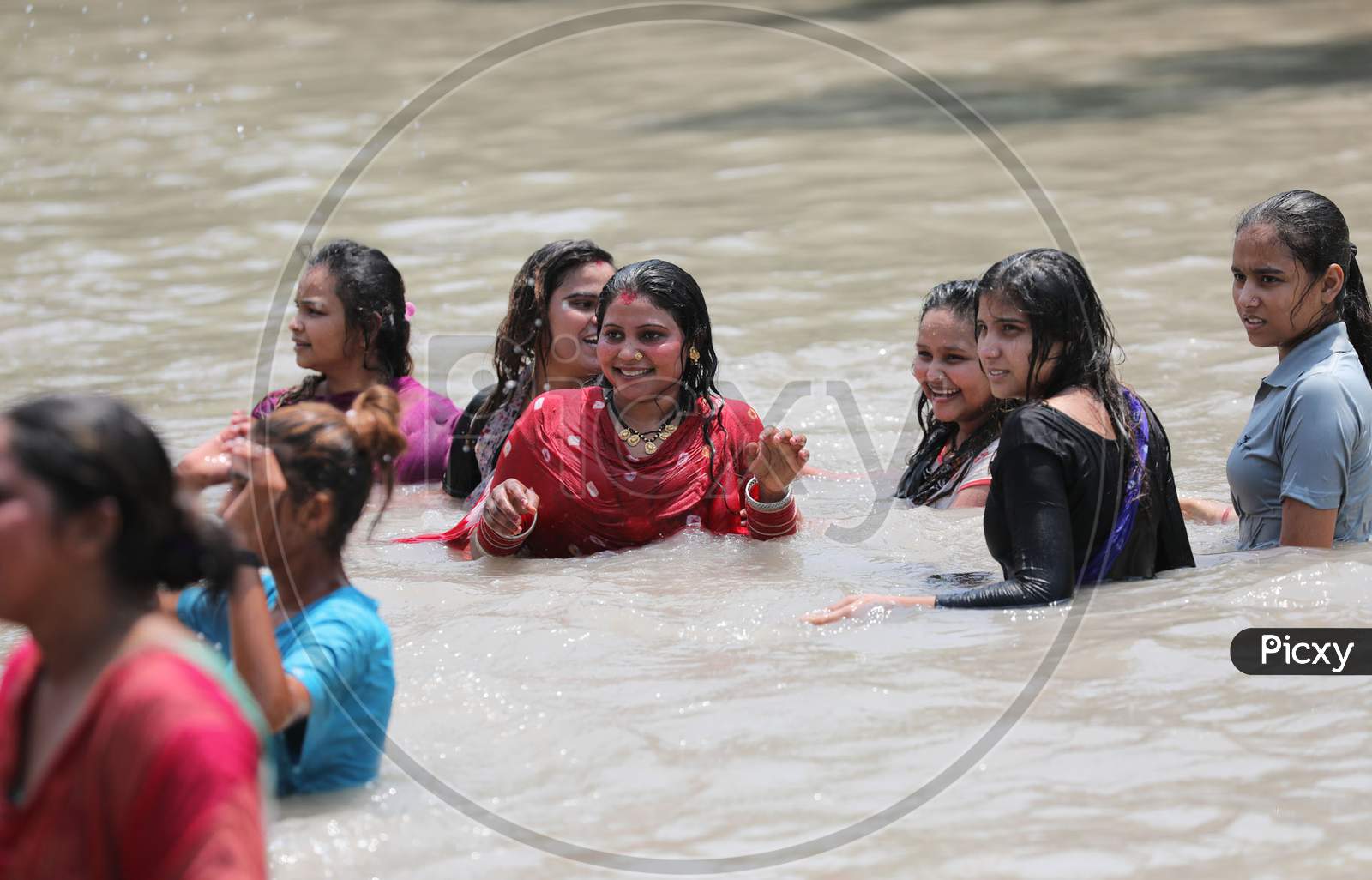 Ladies enjoying a cool dip in waters of Ranbir Canal to beat the summer heat in Jammu on July 2, 2020