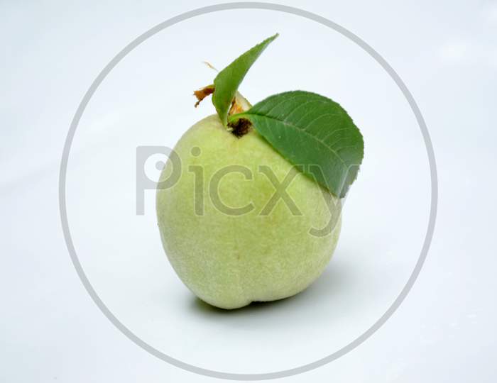 the ripe green peach with leaf isolated on white background.