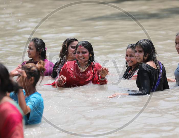 Ladies enjoying a cool dip in waters of Ranbir Canal to beat the summer heat in Jammu on July 2, 2020