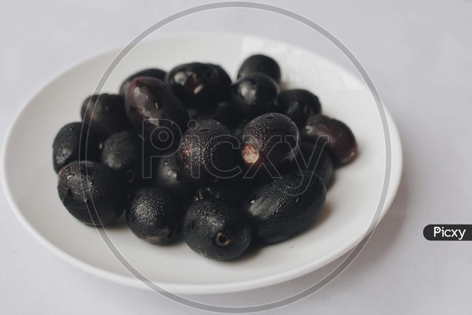 Picture of Java Plum  fruit on white plate, indian Jamun