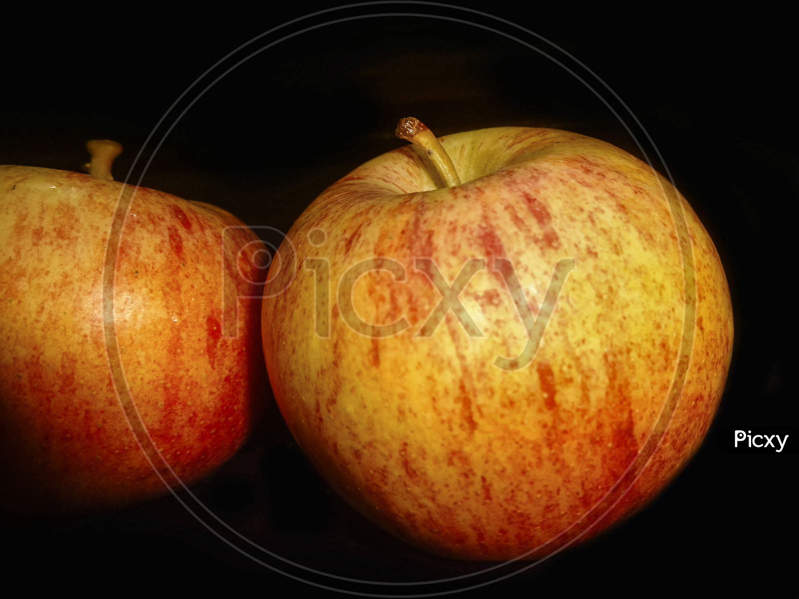 closeup view of two apples with black background