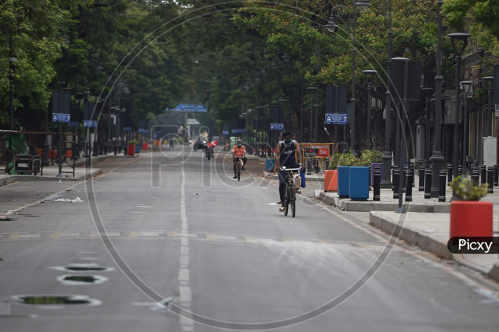 Two men pedal their bicycles on a deserted road after the Government imposed a lockdown in Chennai