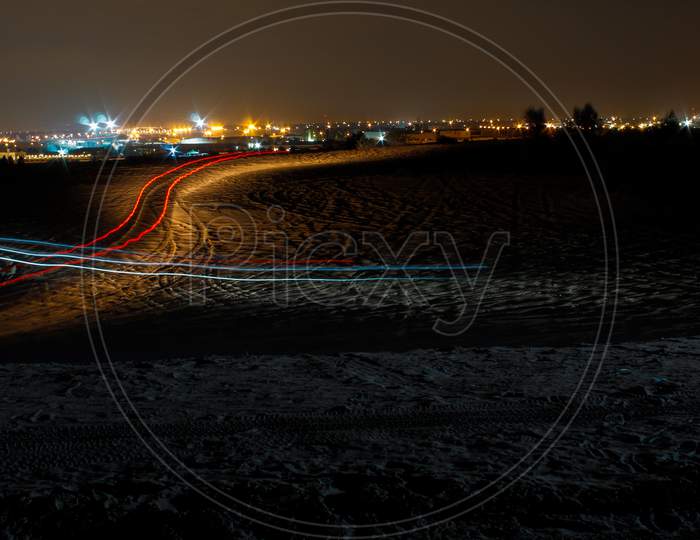 City Scape And Night With Long Exposure Of Cars In The Desert In Uae, Dubai