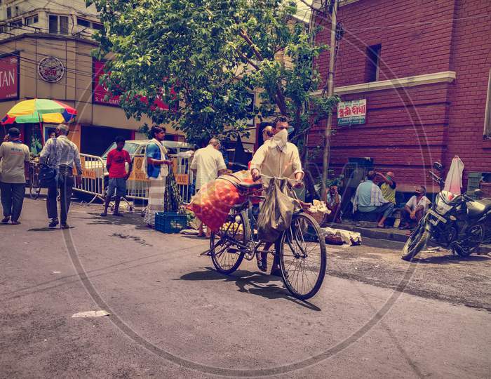 A masked man walking with cycle and a full bag of potato during unlock 2.0 at Lalbazar, Kolkata, West Bengal, India on 1.7.2020