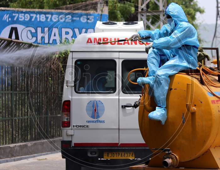 A municipal worker wearing a hazmat suit sprays disinfectant at a crematorium in Rajasthan on July 02, 2020.