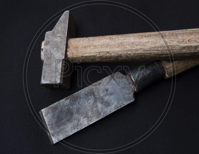 Closeup Shot Of A Hammer And Chisel With Wooden Handles Isolated On A Black Background