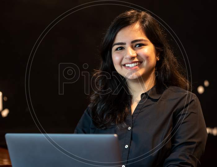 Smiling Young Indian Woman Works On A Laptop
