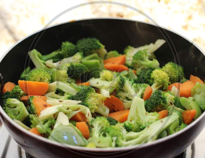 Half cooked vegetables on black fry pan