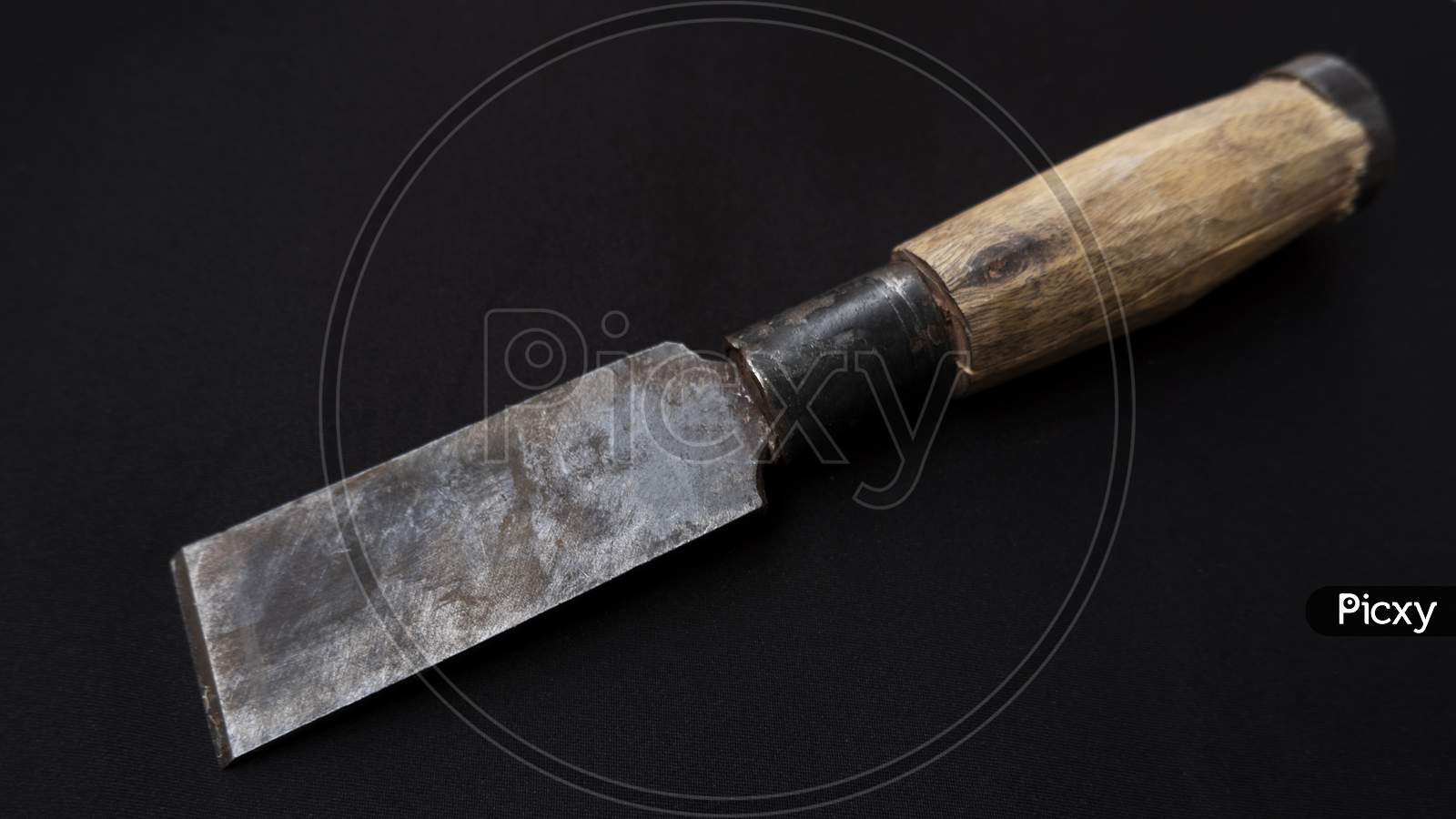 Closeup Shot Of An Old Rusty Chisel With Wooden Handle Isolated On A Black Background