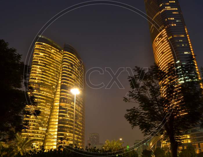 Unique View Of Abu Dhabi Adea Building And Landmark Tower At Night, Cornish Beach Leading To Marina Mall At Golden Hour,