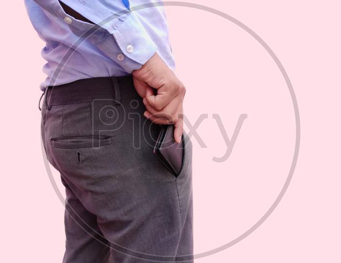 Rear View of man keeping money wallet in front pocket of formal pants on white background