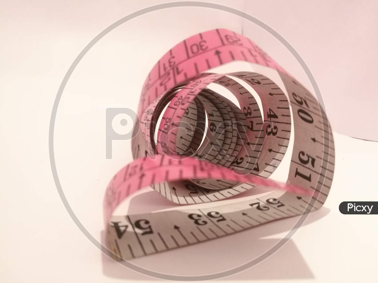 The Tailoring Tape Placed Isolated In A White Background In A Spiral Shape.
