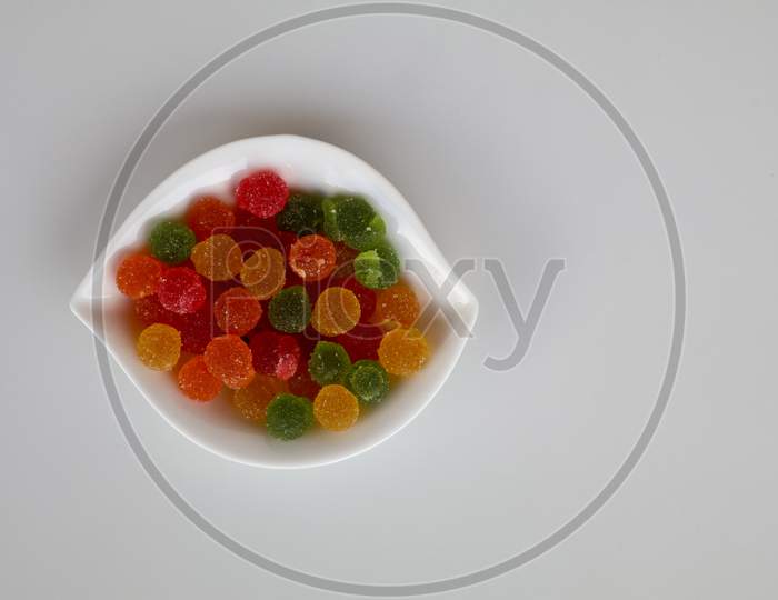 Sweet Mixed Color Jelly Candy In A White Bowl Against White Background With Copy Space