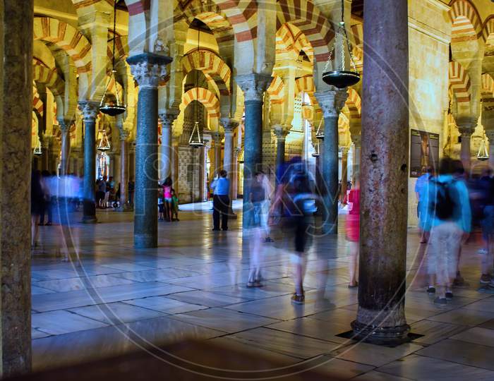 Cordoba, Spain - September 02, 2015: Motion Blurred People Inside A Unesco-Listed World Heritage Site, La Mezquita Is The Great Mosque That Was Created For The Caliphate Of Córdoba