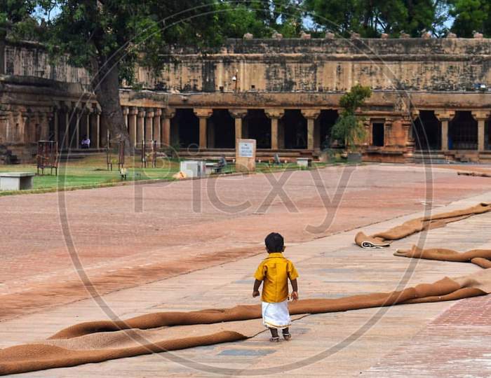 A kid walking in the Brihadeeshwara temple premises, Thabjavur