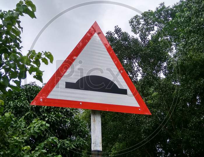A speed bump sign on the side of a road