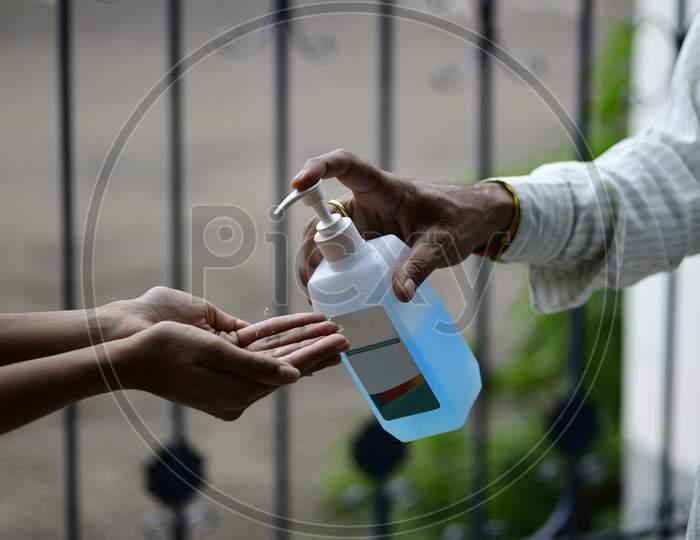 Man dispensing sanitizer solution to a guest