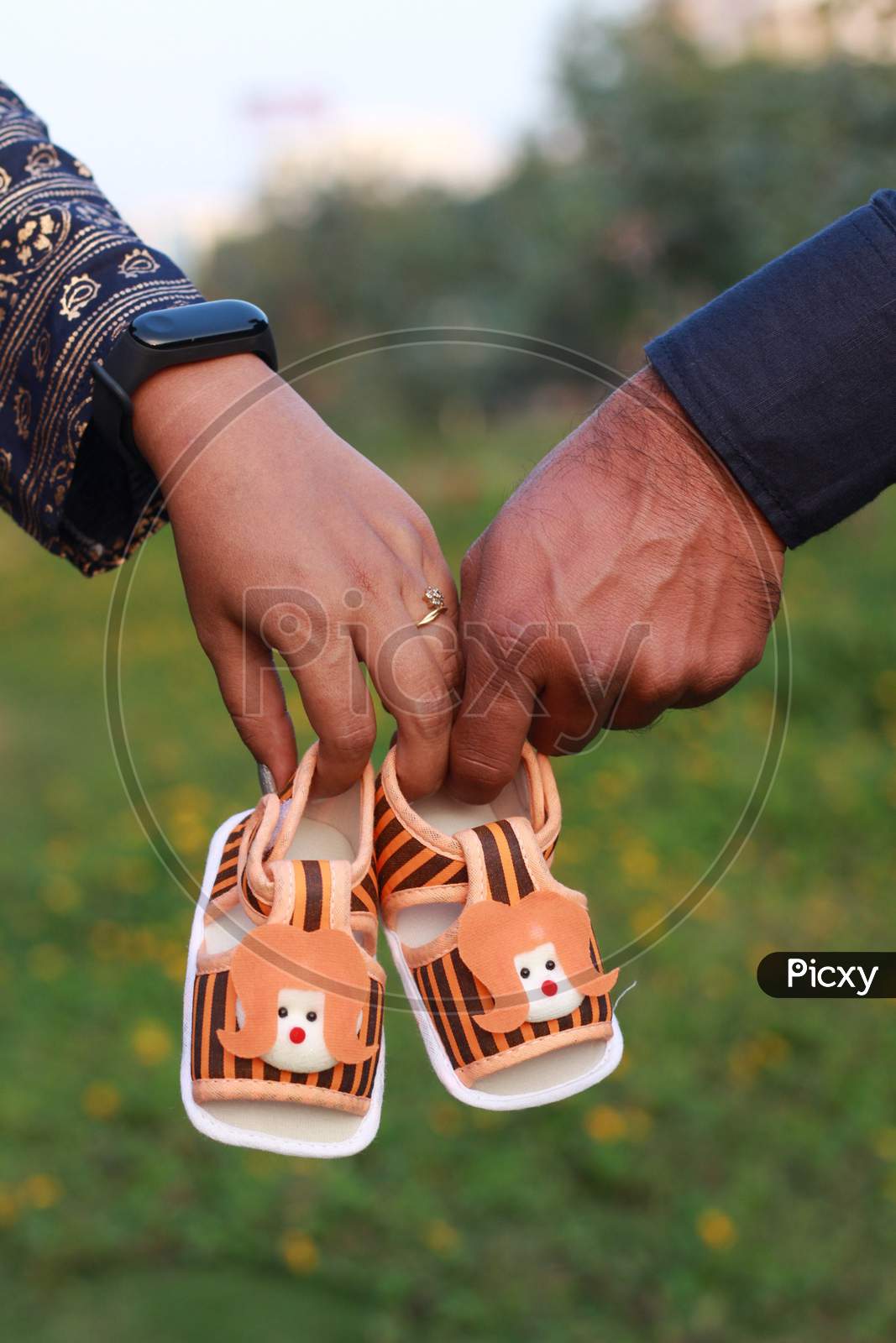 Couple holding baby shoes for maternity photoshoot