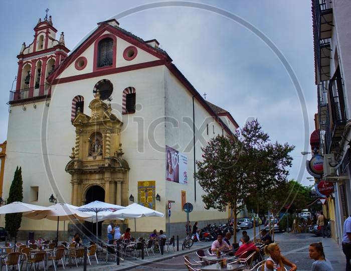 Cordoba, Spain - September 02, 2015: Open Restaurant With Umbrella Serving Mostly Tourists In City Center Before Religious Building
