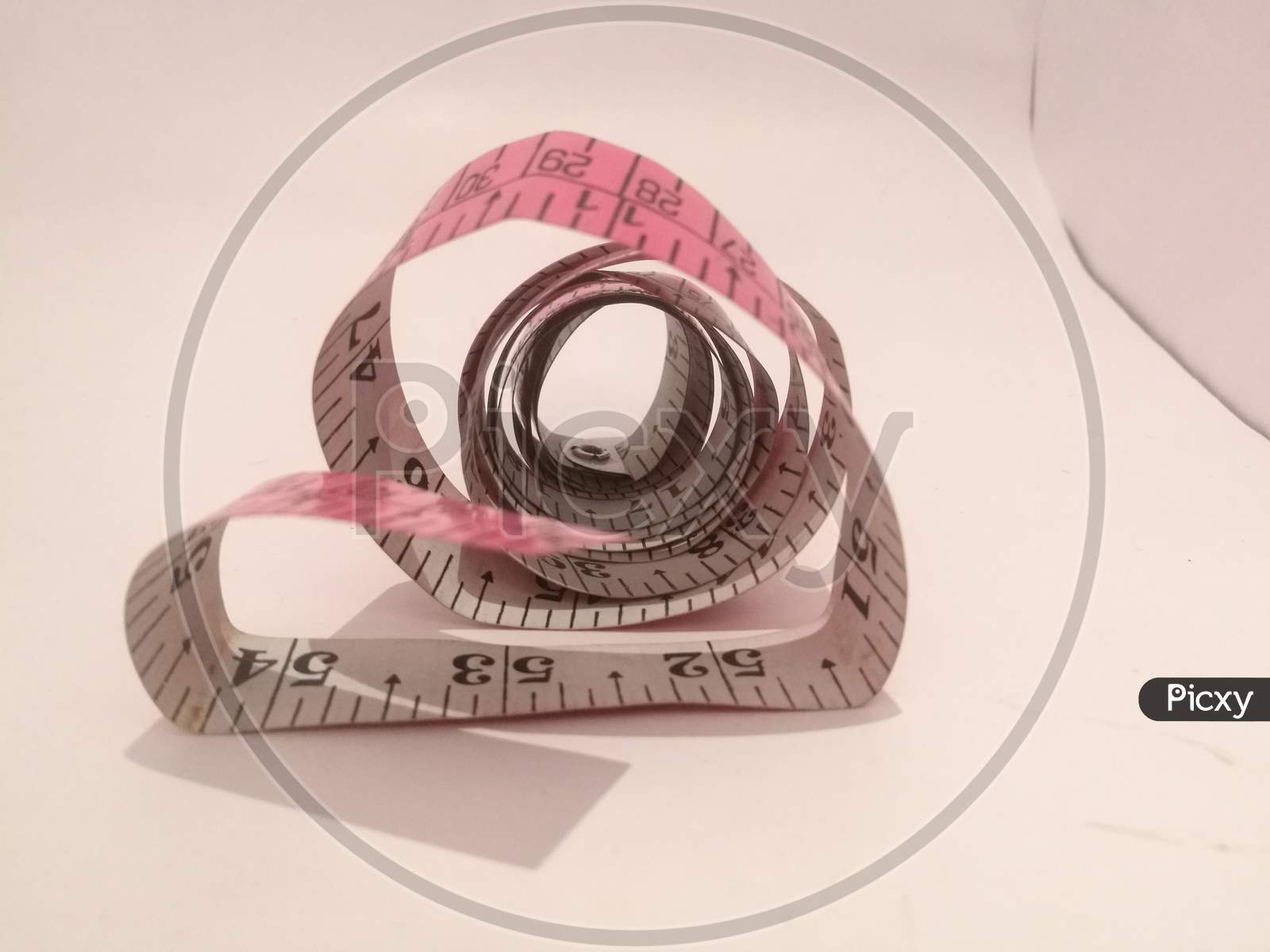 A Tailoring Tape Placed Isolated In A White Background In A Spiral Shape.