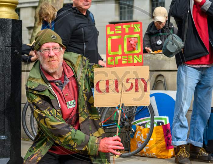 Mature Male Extinction Rebellion Protester Holding Home Made Signs At A Protest March