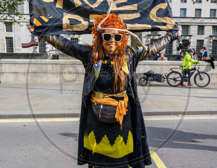 Full Length Vertical Shot Of Extinction Rebellion Protester Holding A Save Bees Banner At An Extinction Rebellion Protest March