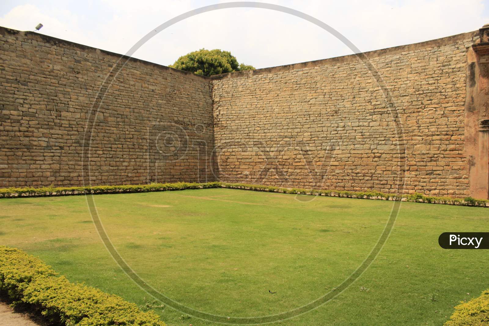 beautiful green lawn with big wall on either side banglore fort