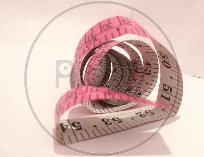 The Tailoring Tape Placed Isolated In A White Background In A Spiral Shape.