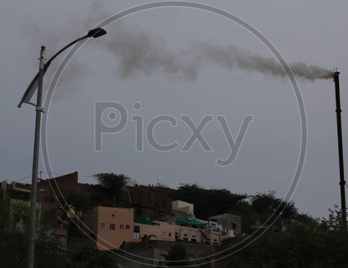 A chimney belonging to a crematorium emits smokes during the cremation of people who died due to coronavirus infection in Ajmer, Rajasthan on July 19, 2020