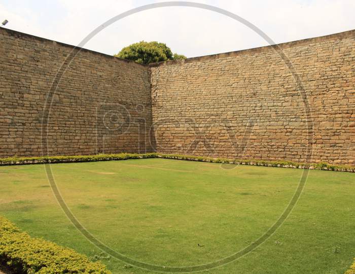 beautiful green lawn with big wall on either side banglore fort