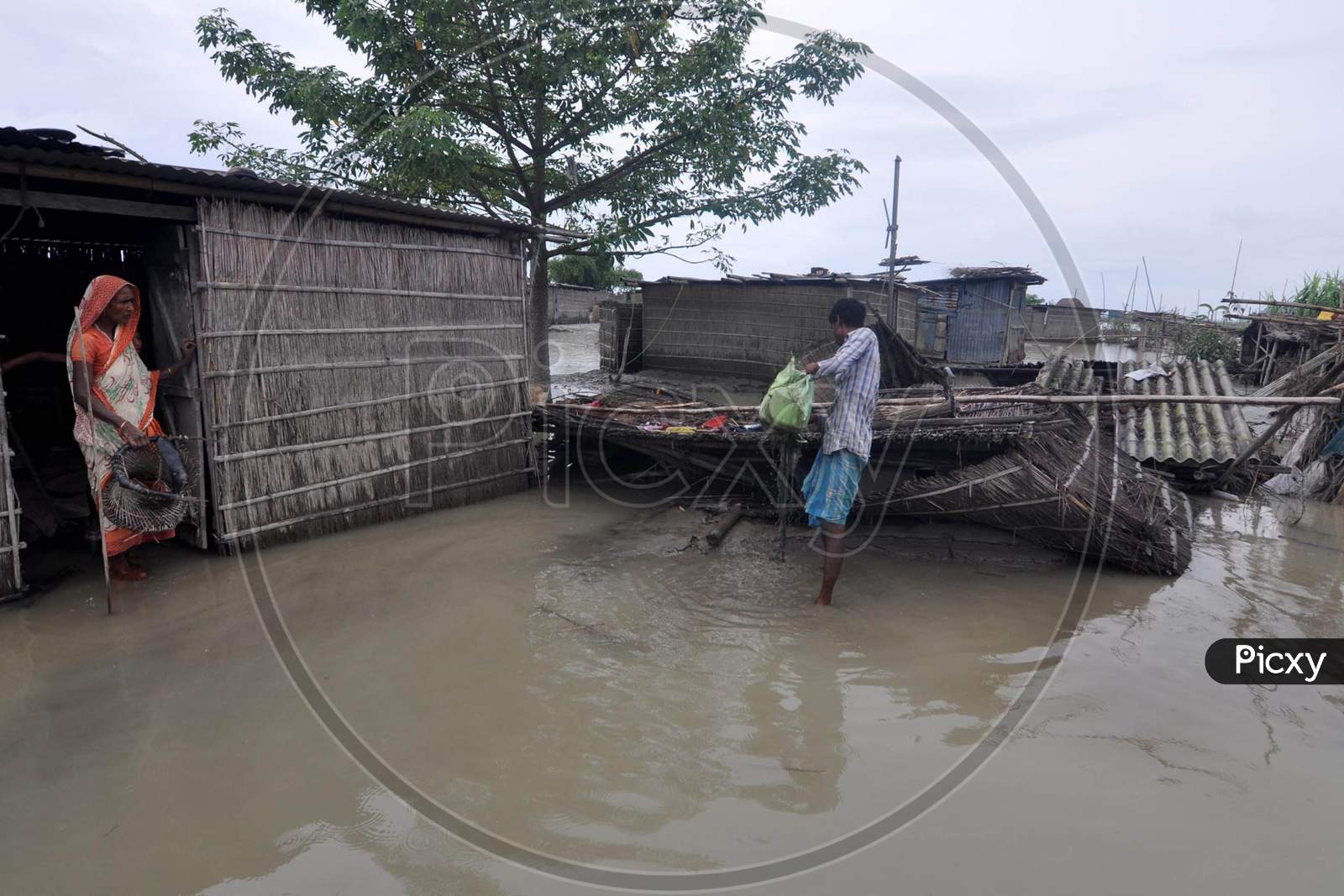Villagers try to rebuild their damaged huts during the flood in Darrang, Assam on July 21, 2020