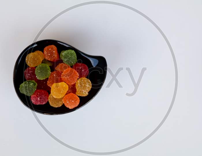Sweet Mixed Color Jelly Candy In A Black Bowl Against White Background With Copy Space