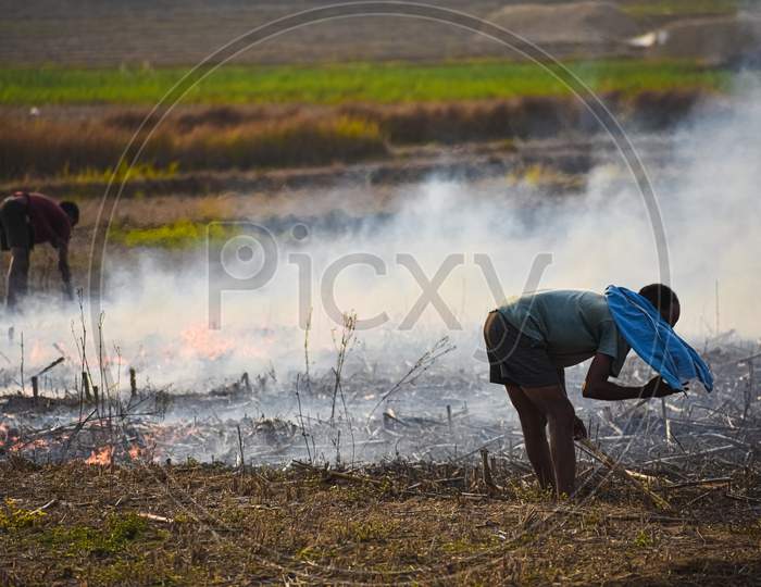 A farmer setting his field on fire.